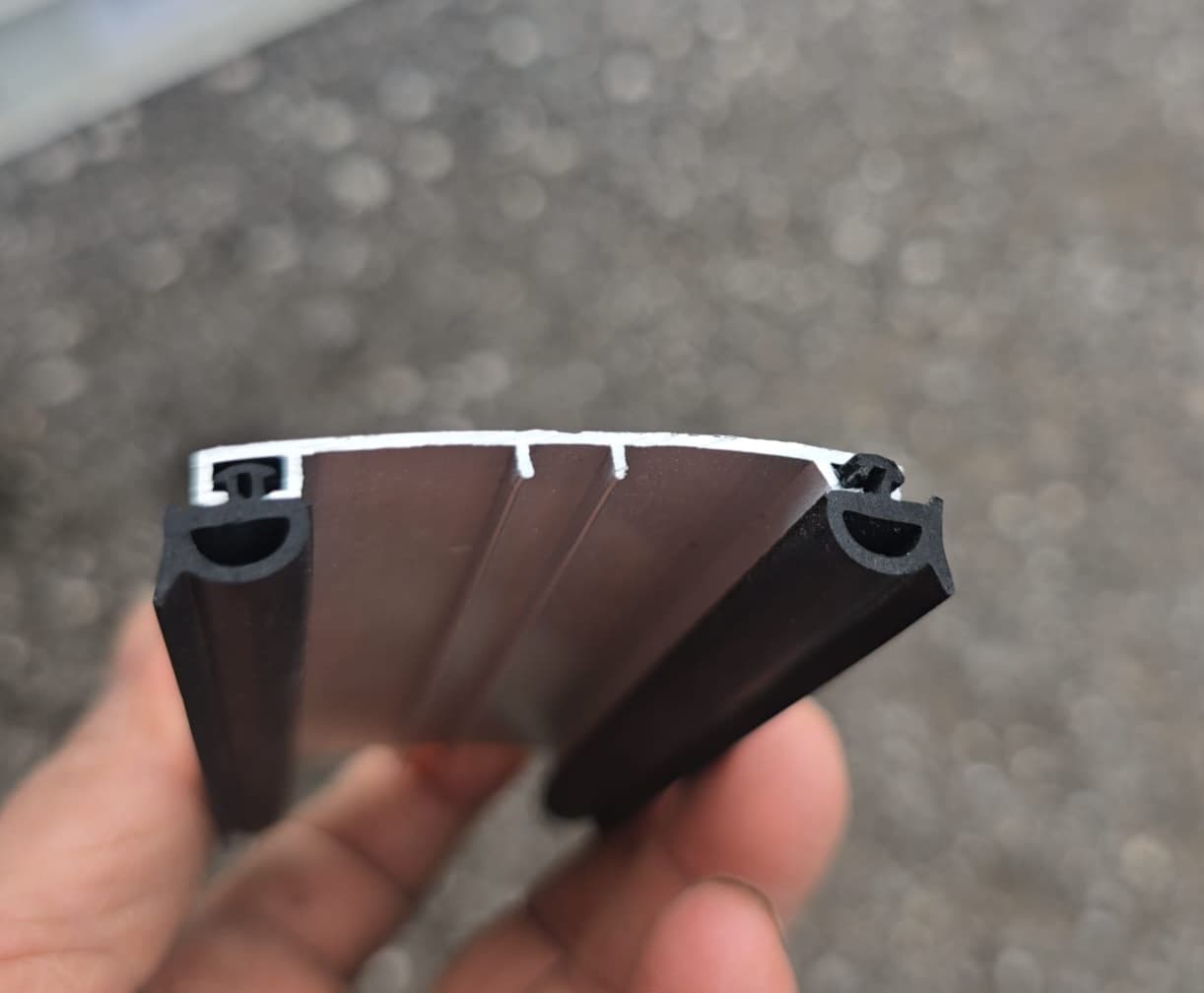 Aluminum snap-on roof connector with black rubber gaskets held in hand